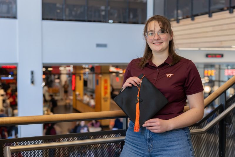Haley Rindfleisch Haley Rindfleisch holds a graduation cap and tassel in her hands. She is wearing a maroon Virginia Tech shirt and blue jeans. She's standing against a stair railing in Hitt Hall.