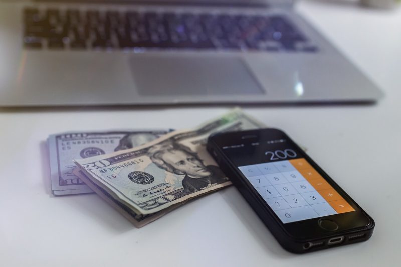 Computer with calculator and twenty dollar bills.