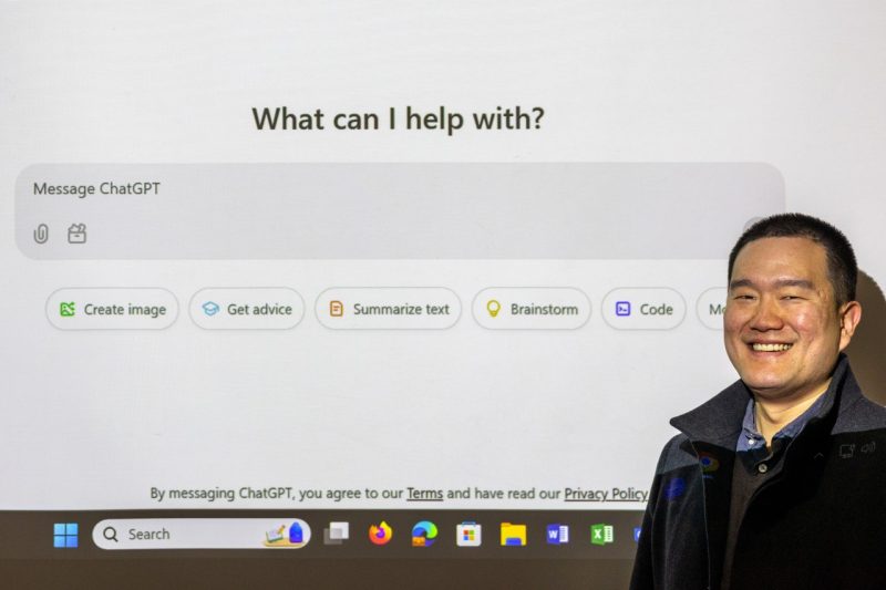 Junghwan Kim ChatGPT - What can I help with? A professor stands in front of a projection of the ChatGPT website, text reads: "What can I help with? Message ChatGPT"