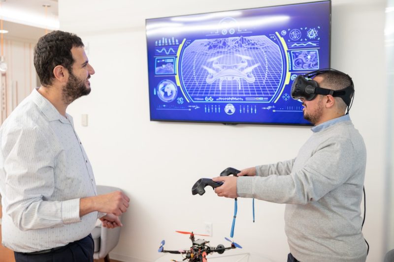 Two people use VR headset.