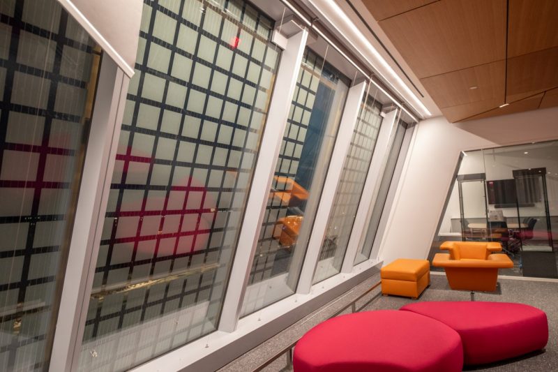 interior of a building with bright furniture and photovoltaic panels on the windows