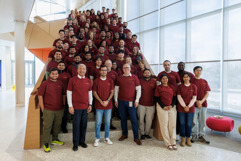 group of diverse people in matching shirts on a staircase