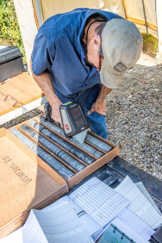 A researcher conducting tests with handheld analytical instruments.