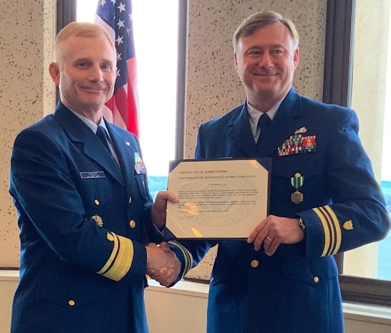 Rob Starr in Coast Guard uniform accepts a certificate