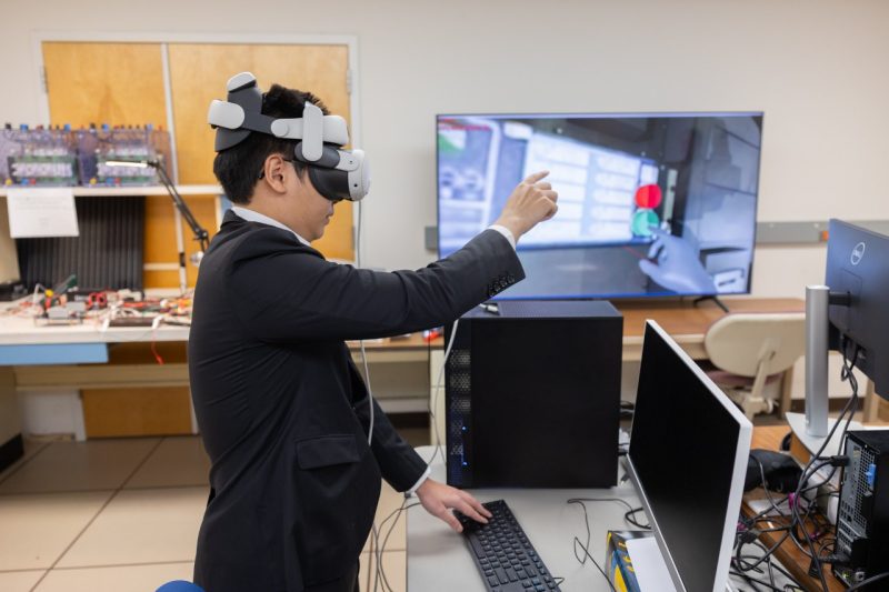 Virtual Reality and Headset Nguyen Khoa Nguyen wears a virtual reality headset while demonstrating the digital twin and virtual reality system at a recent Power and Energy Conference at Virginia Tech.
