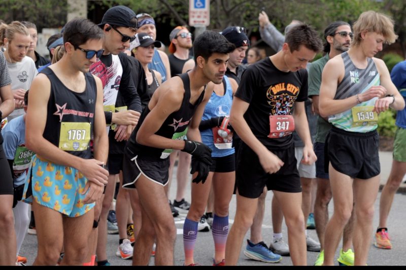 Runners toe the starting line prepared to begin a race. Varum Mishra is in the front row, second from left.