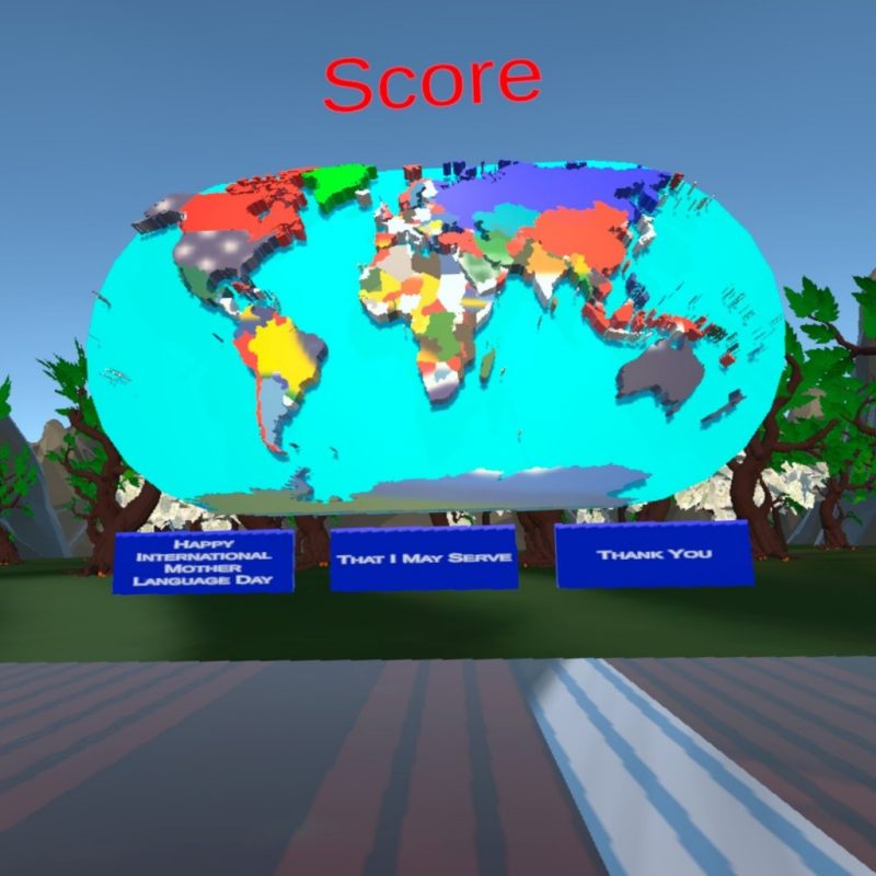 A scene from the virtual reality game Ibrahim Tahmid created for International Mother Language Day. Photo courtesy of Ibrahim Tahmid. An animated globe is positioned in front of an outdoor scene with green trees, rocks, and a blue sky. Three blue boxes below the globe read: Happy International Mother Language Day, That I May Serve, and Thank You.