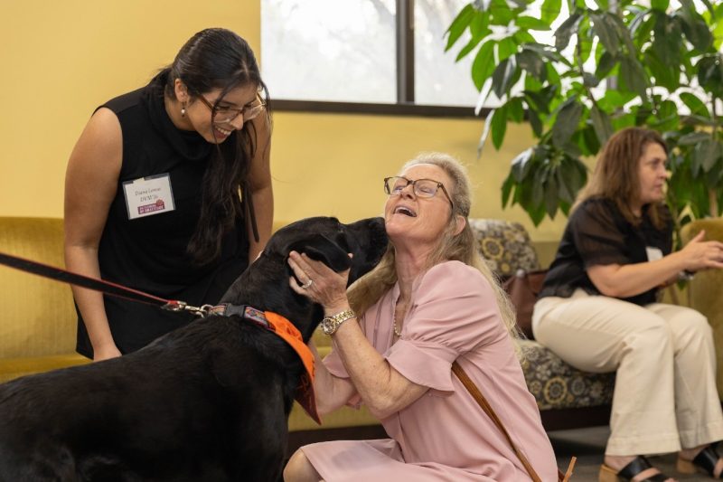 Evening of Gratitude (From left) Diana Lemus and Jennifer Stanton petting Epcot, a black lab dog, at Evening of Gratitude