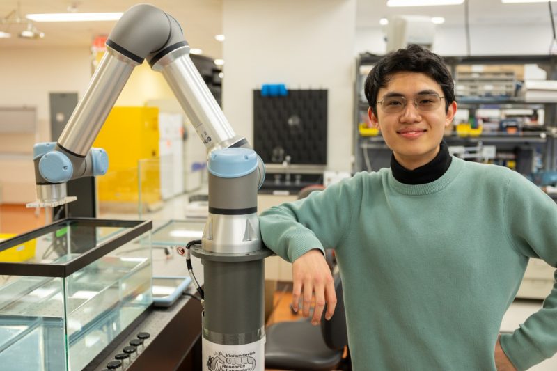 Thomas Lu - in the Lab Thomas Lu stands next to a robotic arm in the Vlaisavljevich Research Lab. Photo by Ben Murphy for Virginia Tech.