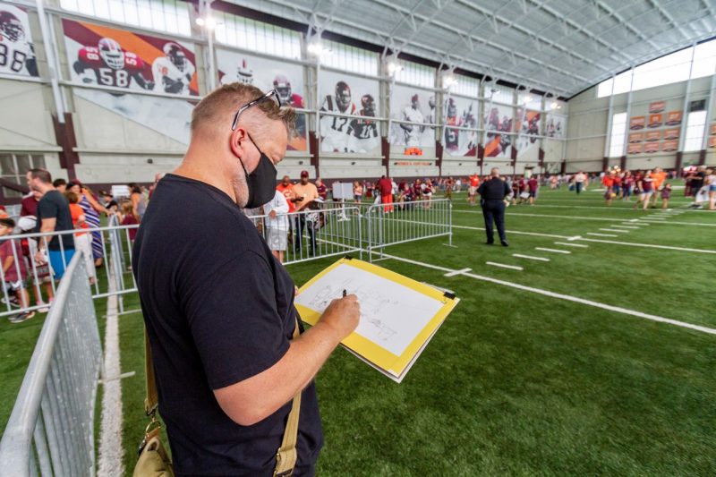 Steven White sketches at the 2021 Fan Day activities inside the Beamer-Lawson Indoor Practice Facility (Photo by Ivan Morozov)