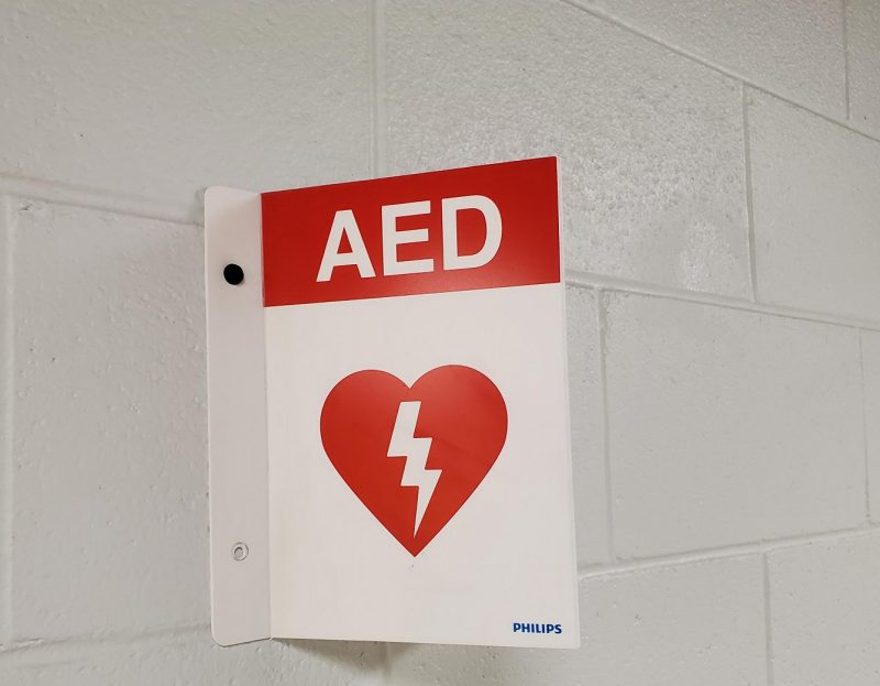 A red and white sign with a lightning bolt in a heart symbol reading AED