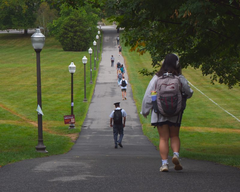 Students walking on the Drillfield on a rainy morning. 